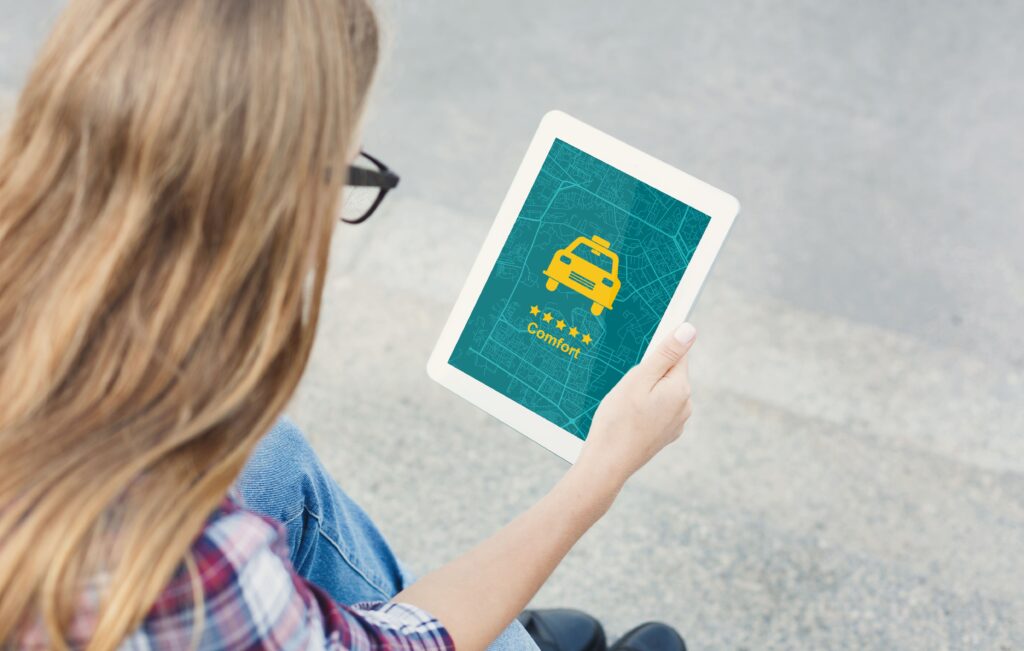 κοπέλα ψάχνει μέσω της εφαρμογής ταξί από το tablet να βρει ταξί 