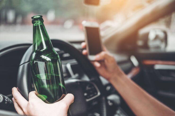 οδηγός με το ένα χέρι στο κινητό και το άλλο στο μπουκάλι μπύρας ενώ οδηγεί παράλληλα
