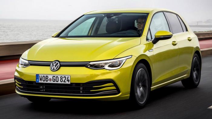 Οδηγός οδηγεί το αυτοκίνητο Volkswagen Golf σε κίτρινο χρώμα σε δρόμο με θέα τη θάλασσα