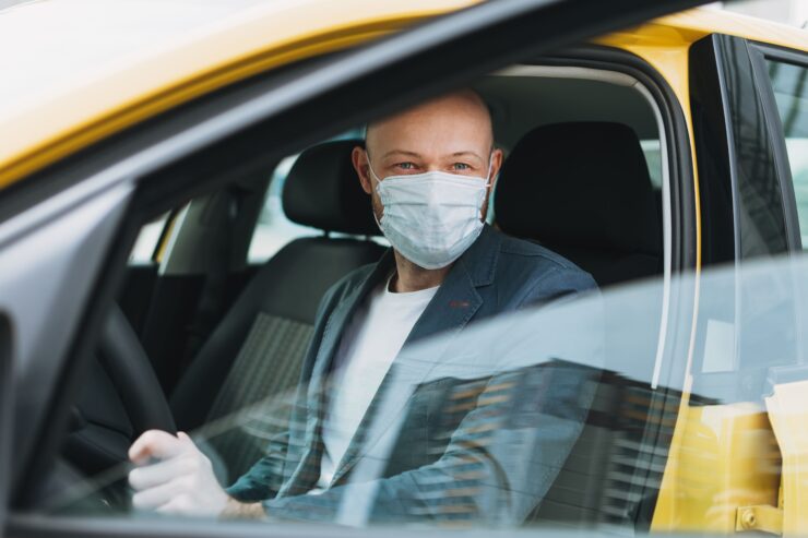 Οδηγός ταξί φοράει τη μάσκα του πριν πάρει πελάτη για διαδρομή