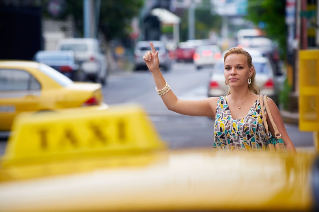 Γυναίκα σηκώνει το χέρι της για να σταματήσει το ταξί