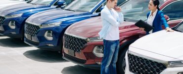 νέος άντρας ψάχνει σε έκθεση με μεταχειρισμένα αυτοκίνητα να αγοράσει αυτοκίνητο