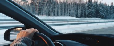 Άνδρας οδηγεί σε δρόμο με χιόνι