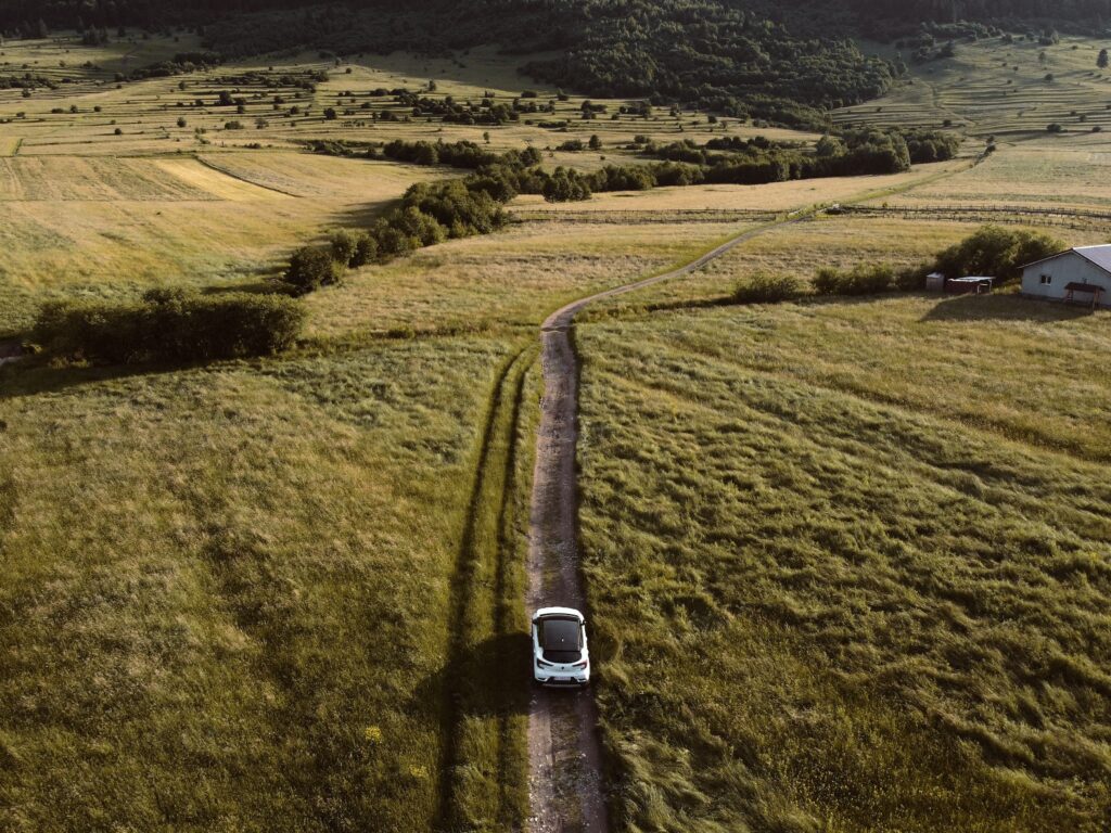 Ηλεκτρικό αυτοκίνητο σε δρόμο με καταπράσινο τοπίο στη Ρουμανία