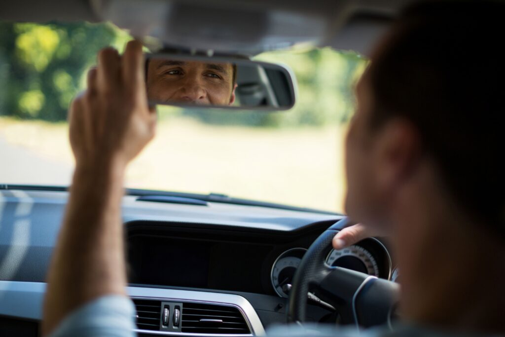 Άνθρωπος που ρυθμίζει τον καθρέφτη στο αυτοκίνητο