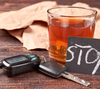 Ένα ποτήτι με αλκοόλ, δίπλα σε κλειδιά αυτοκινήτου με την προειδοποίση γραμμένη σε χαρτάκι ''STOP''