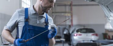 Μηχανικός αυτοκινήτου ελέγχει τα λάδια αυτοκινήτου σε όχημα πελάτη